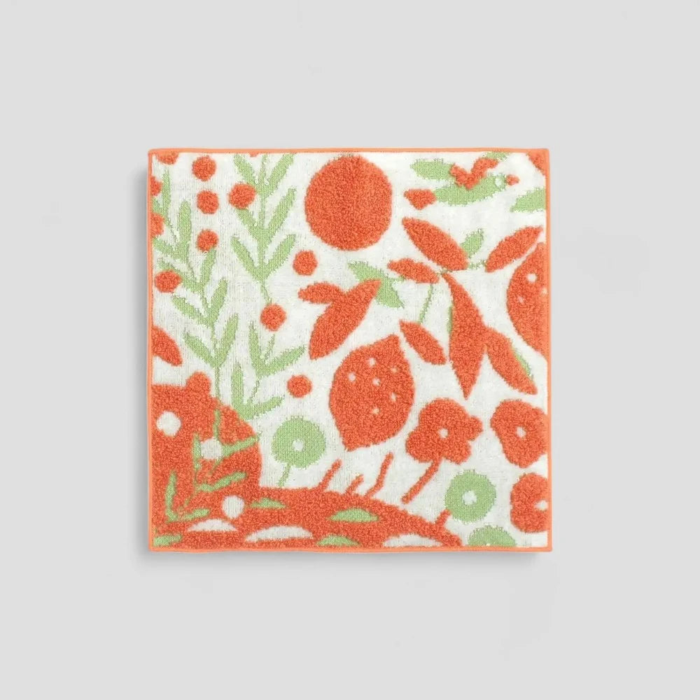 Small Imabari towel with multicolored patterns, including orange tones, made from 100% cotton.