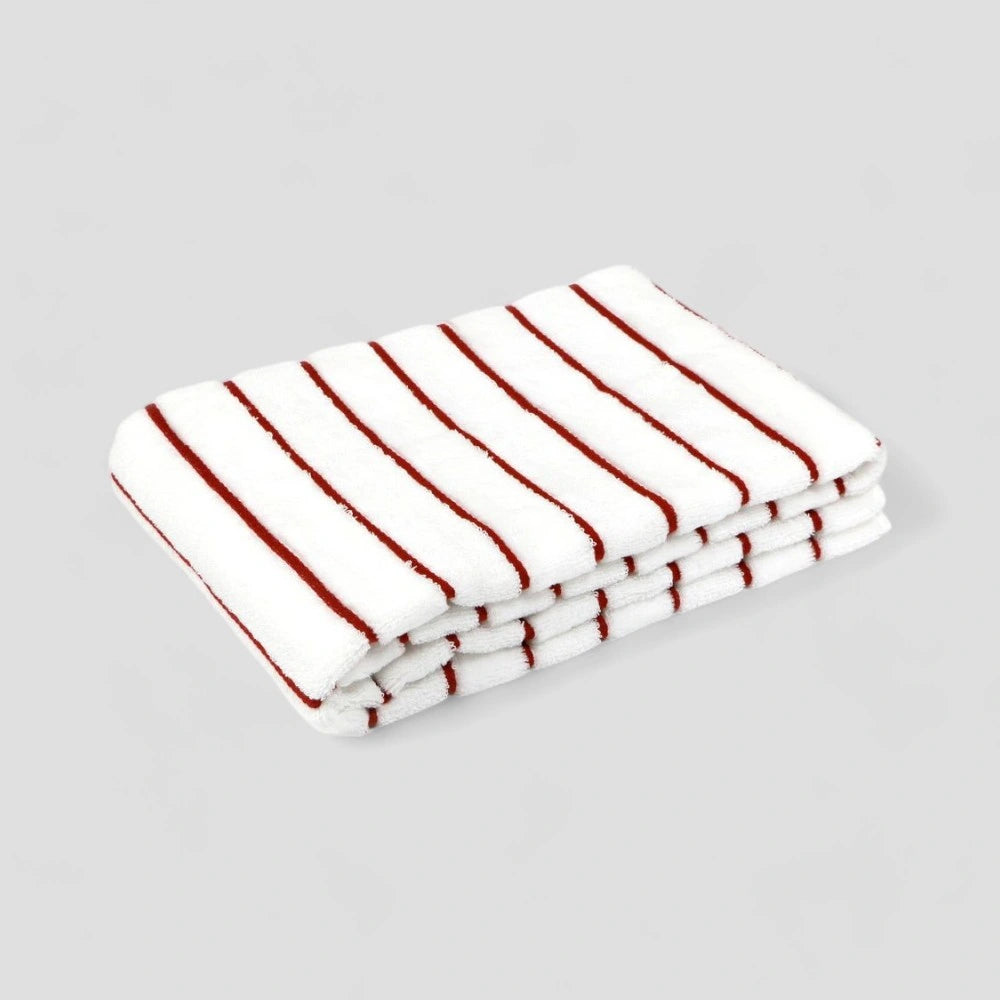 Folded white Imabari towel with red stripe on the gray background