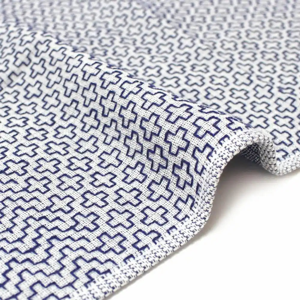 Close-up of a side of a white Imabari towel with a geometric pattern.
