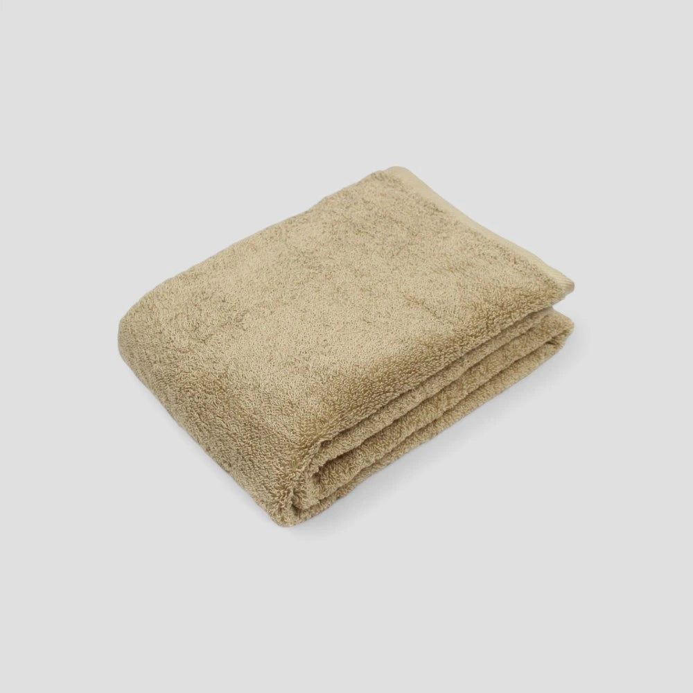 Folded beige Imabari towel on the gray background