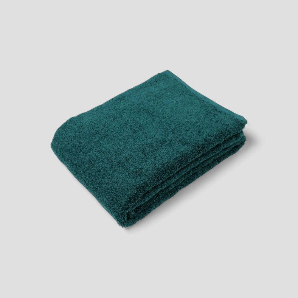 Folded green Imabari towel on the gray background