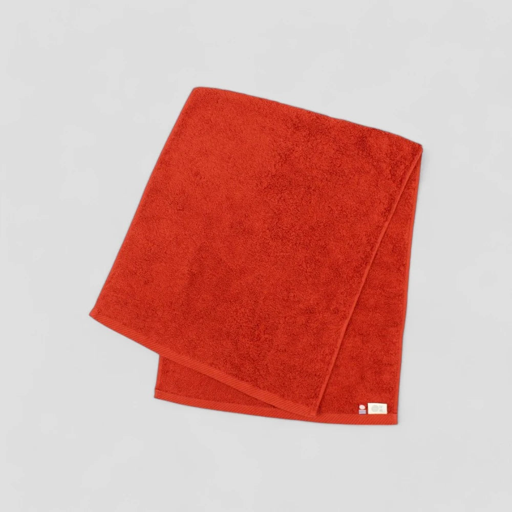 Folded red Imabari towel showing brand labels