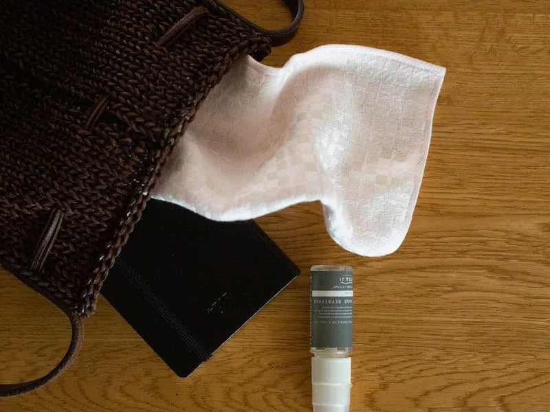 Leave a pink Imabari towel on the table with a mini bottle and a notebook