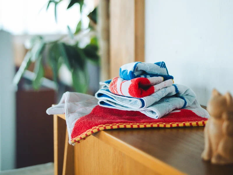 Leave folded red and blue pattern Imabari towels on the desk