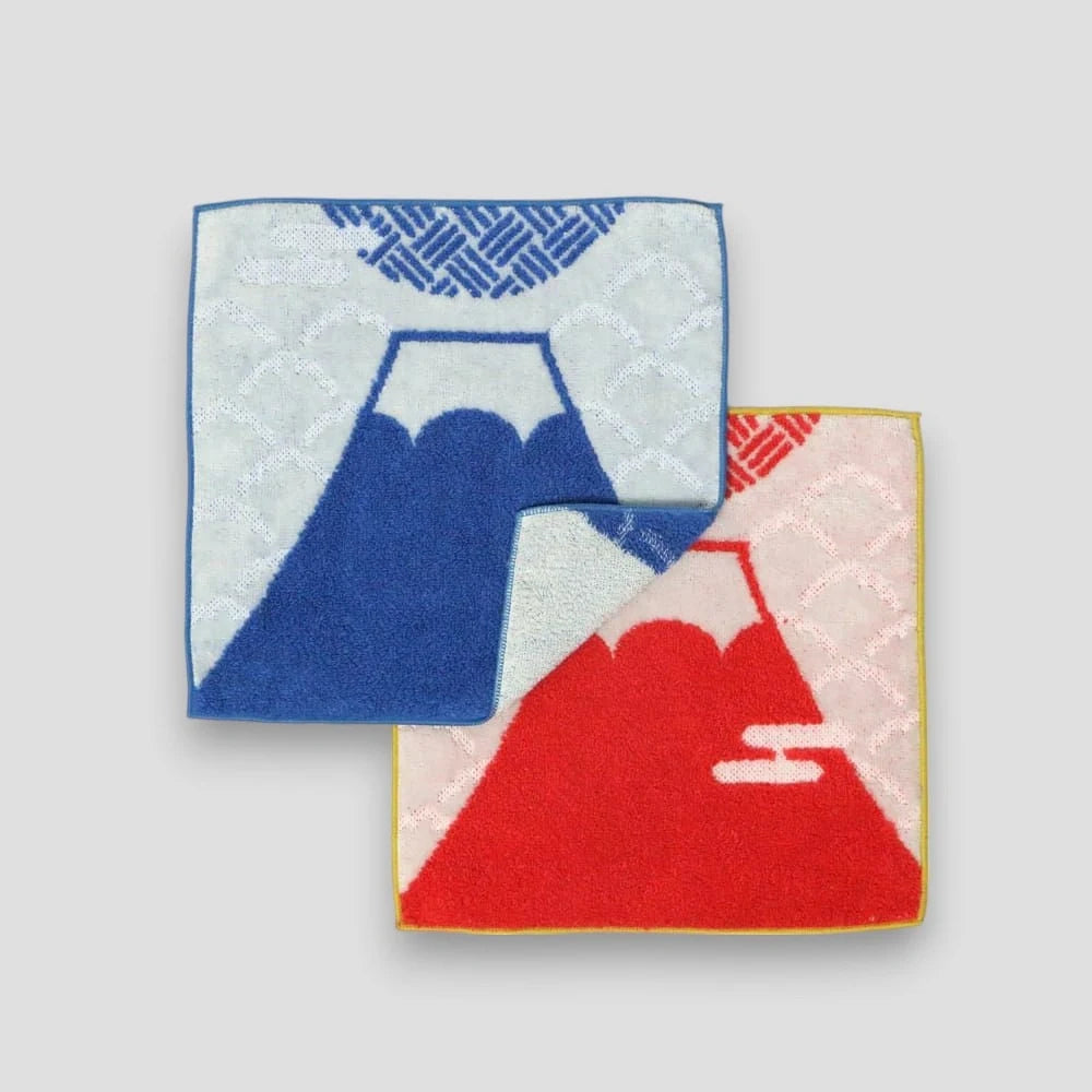 A set of folded square small Imabari towels featuring geometric patterns and Mt. fuji, with blue and red colors prominently displayed, on a white background.