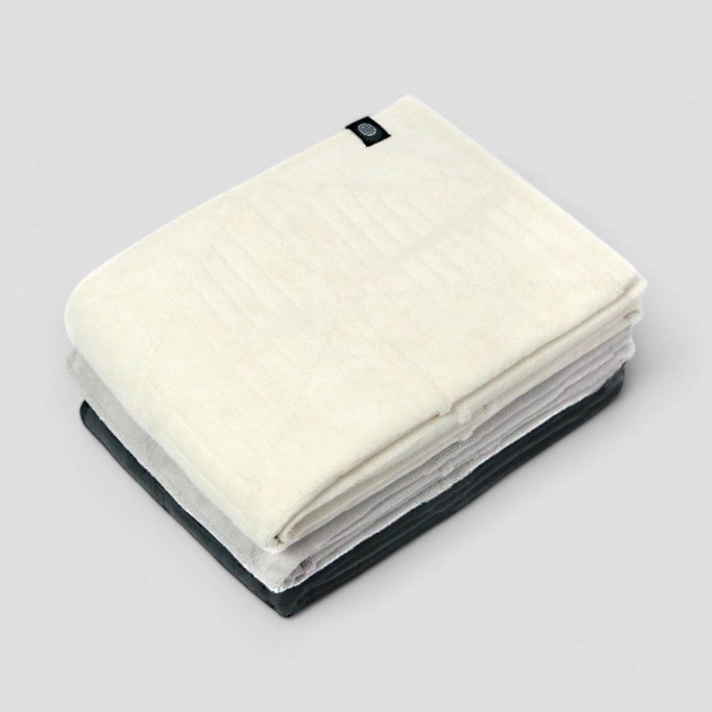 Stack of folded Imabari towels in various colors on a light gray