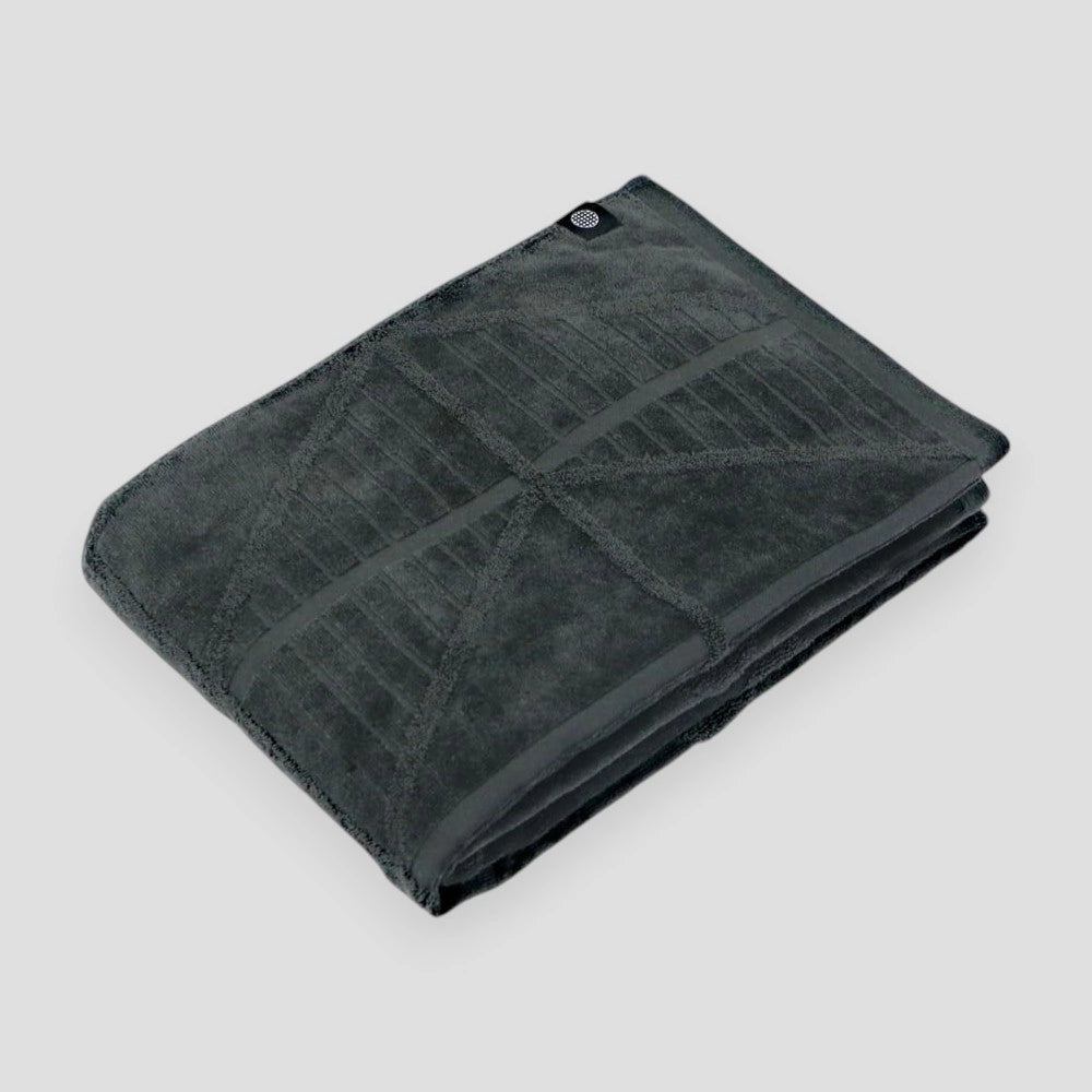 A folded charcoal Imabari towels on a light gray background