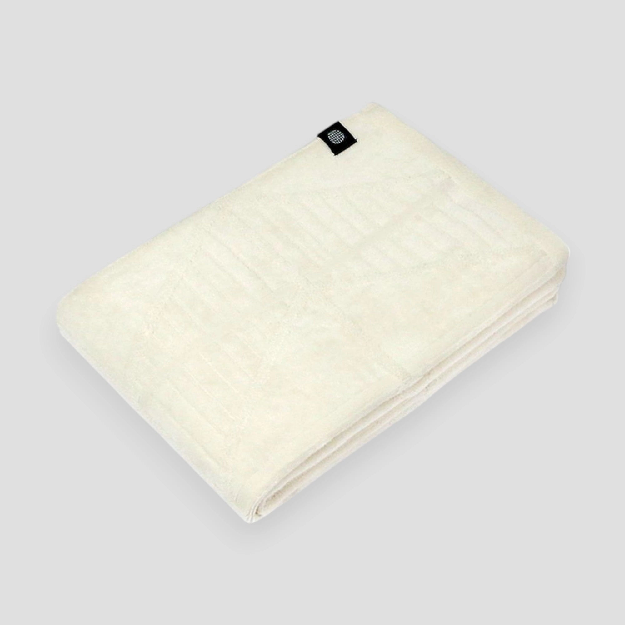 A folded white Imabari towels on a light gray background