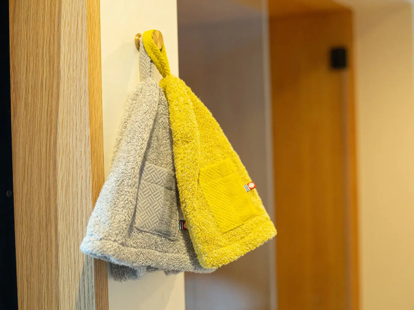 KASUMI sauna hats made from Imabari towel material (yellow, gray) are hanging on the wall