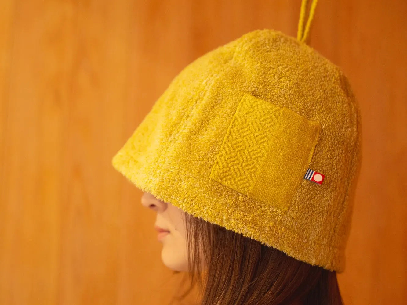 Wearing a yellow sauna hat made from Imabari towel material