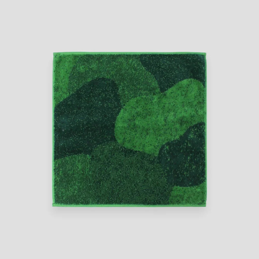 A Imabari towel in green resembling moss laid out flat.