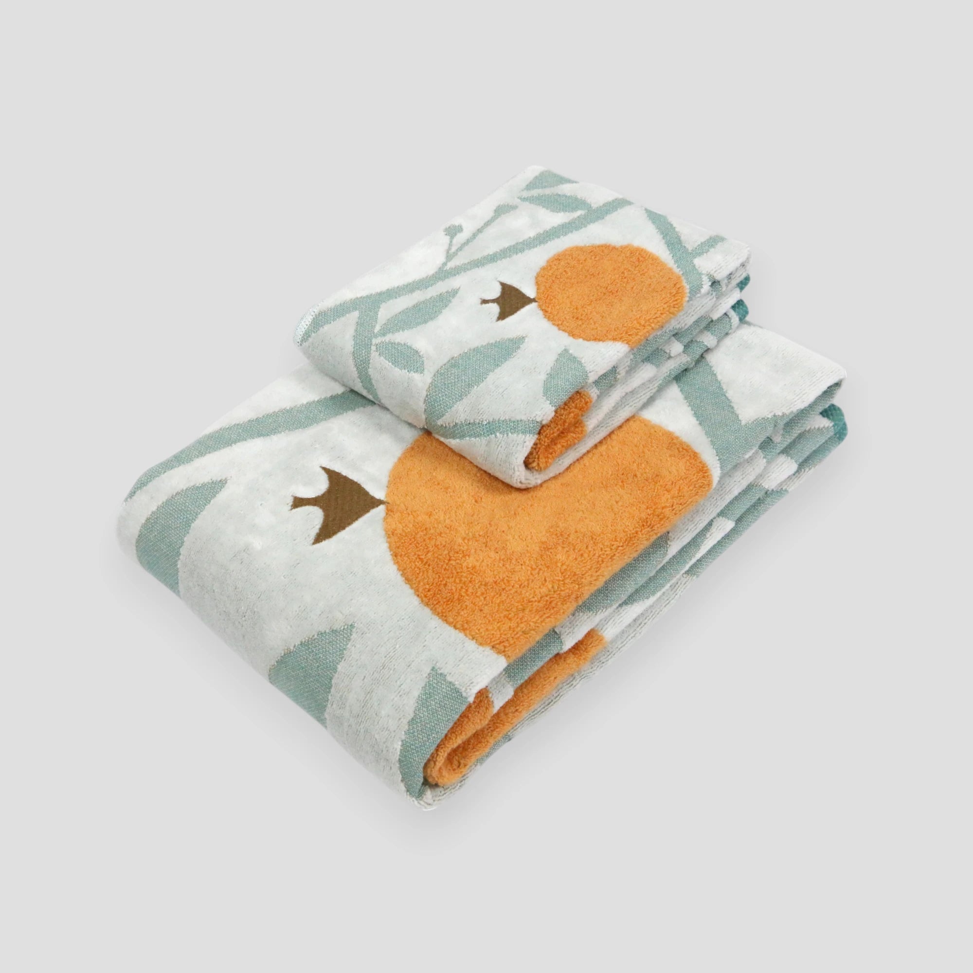 A set of folded Imabari towels with a bird pattern in orange and green colors.