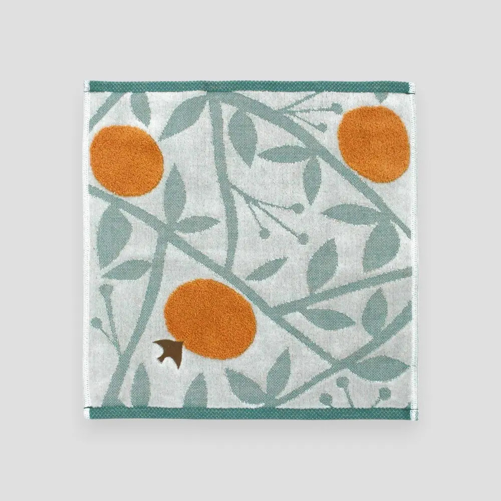 A multicolored square Imabari towel with a bird, orange and leaf pattern