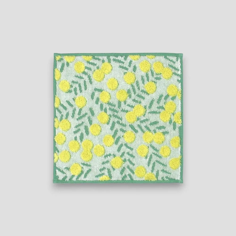A white small Imabari towel with yellow floral pattern