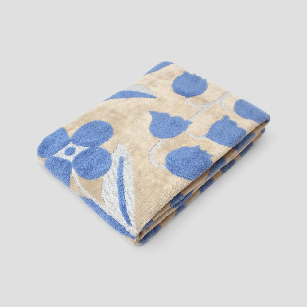 Folded Imabari towel with a blue floral jacquard pattern in baige.
