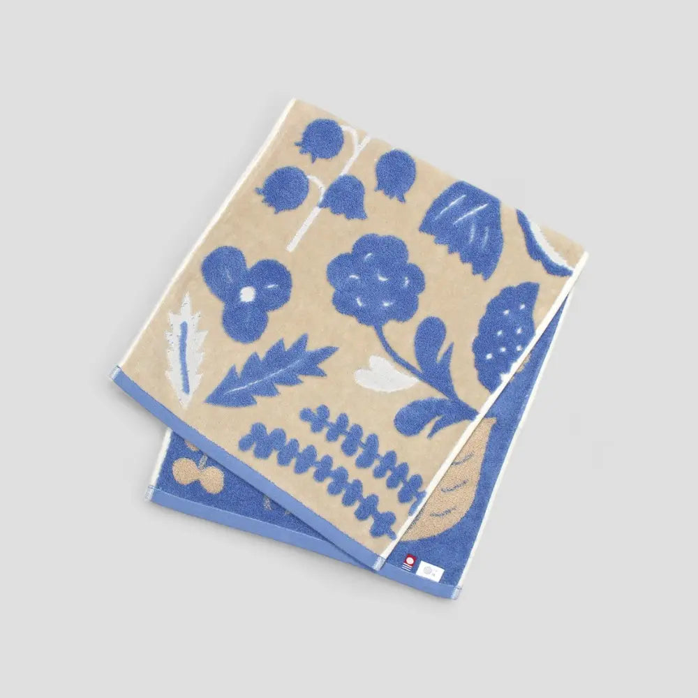 Beige Imabari towels with a blue floral jacquard pattern