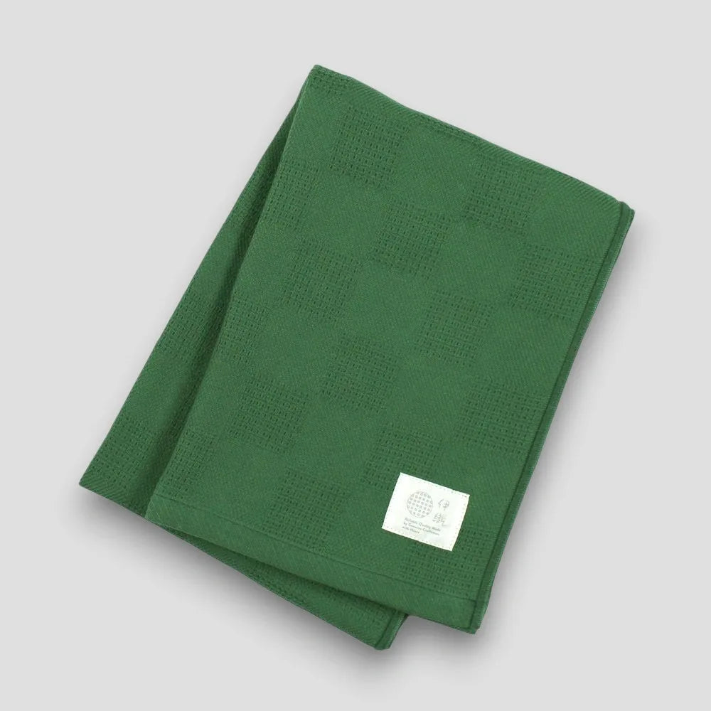 Folded green "Non-Pile" Imabari towel on a light gray background
