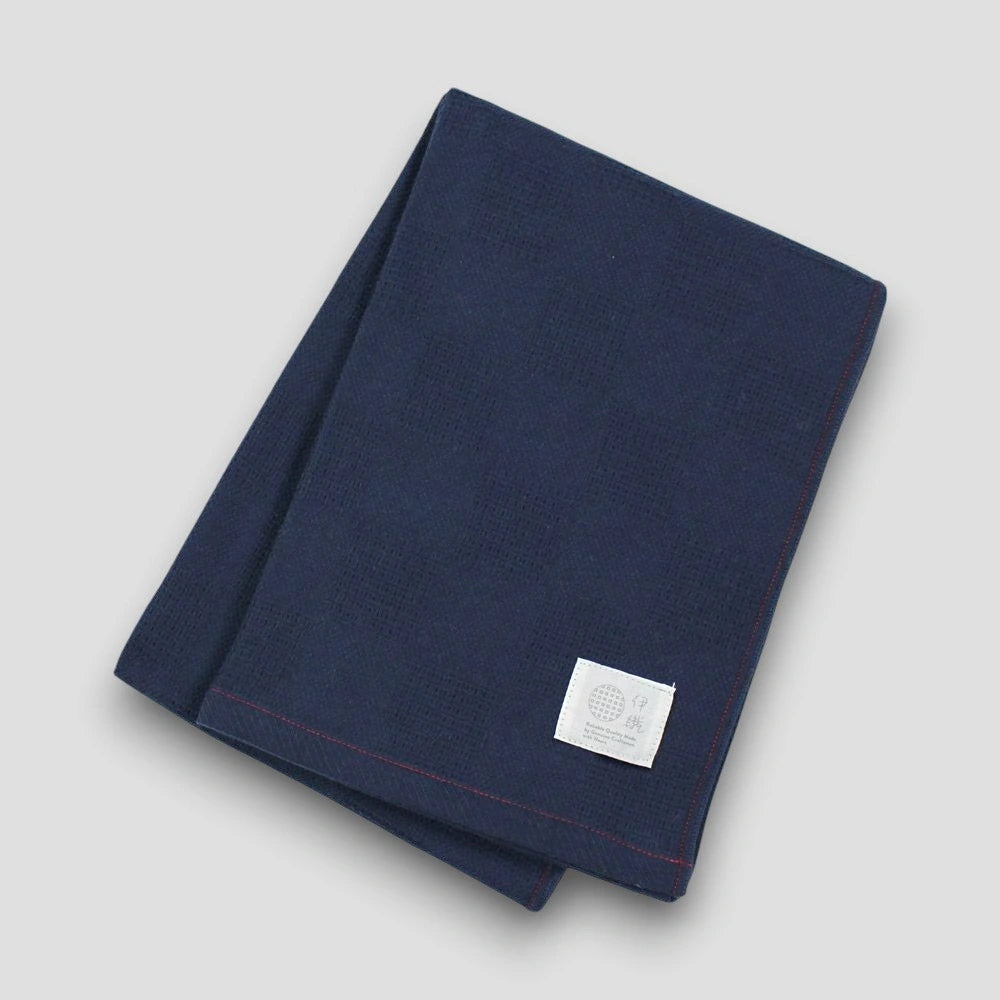 Folded navy "Non-Pile" Imabari towel on a light gray background