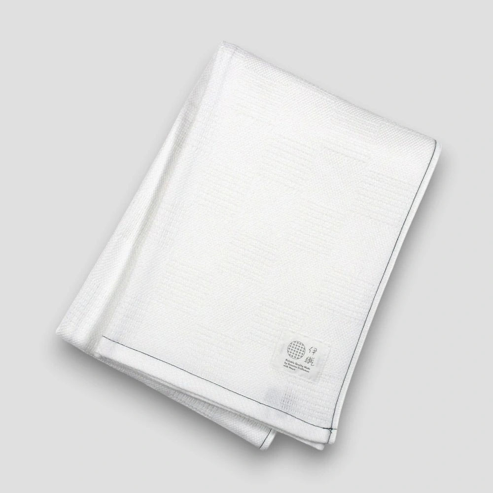 Folded white "Non-Pile" Imabari towel on a light gray background