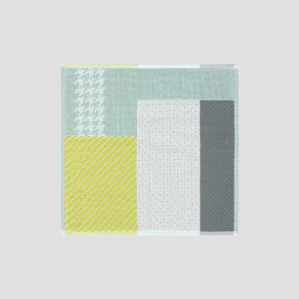 A colorful patchwork design Imabari towel in various colors including yellow, and gray displayed against white background