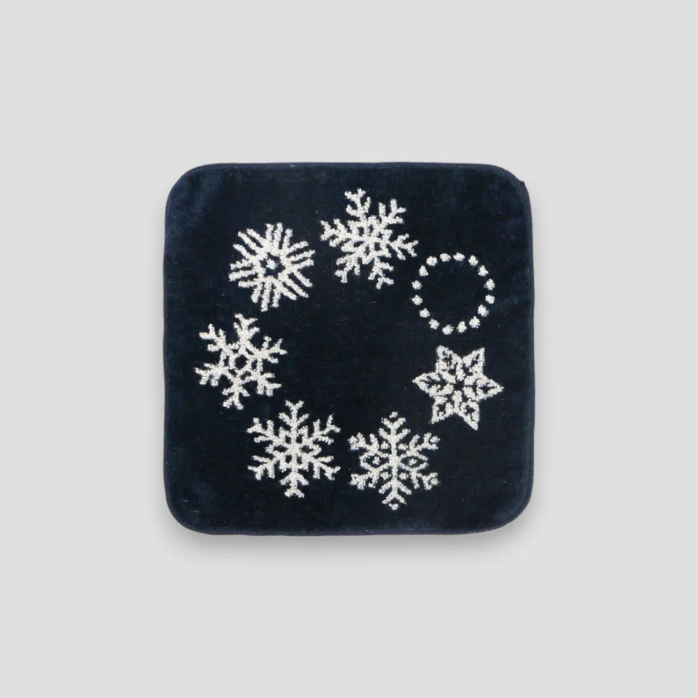 Navy square Imabari towel with white snowflake patterns on a light gray background