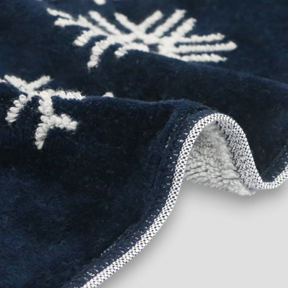 Close-up of a navy Imabari towel corner on a light gray background