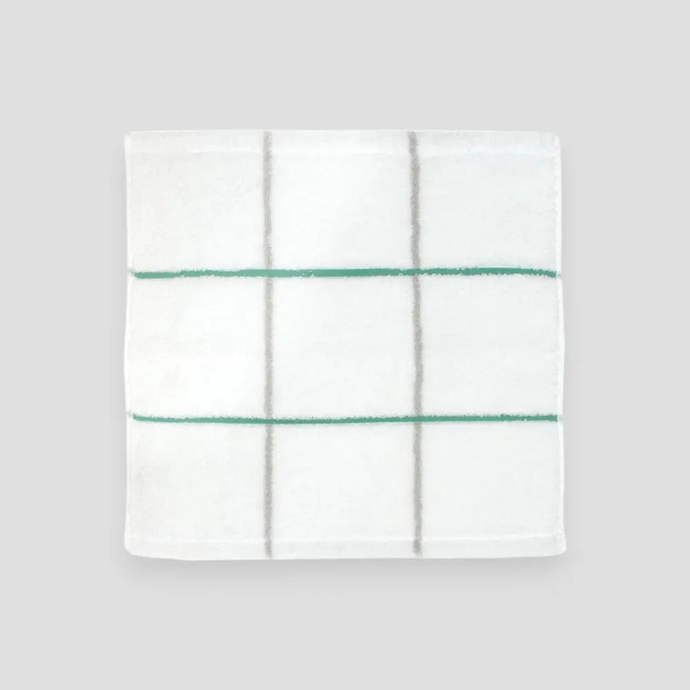 Square white Imabari towel with green stripe on gray background