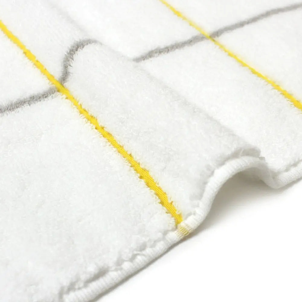 Close-up of a side of white Imabari towel with yellow and gray line