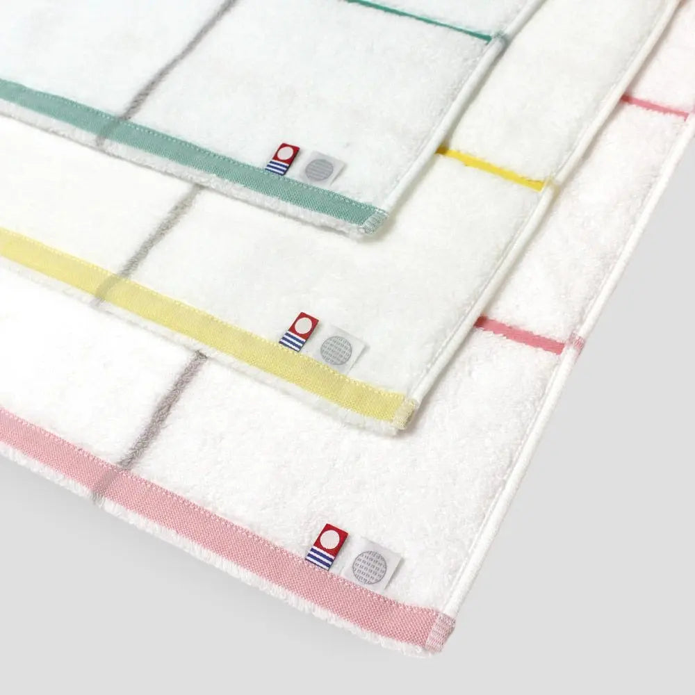 Close-up of three Imabari towels with labels Imabari brand mark and IORI brand logo