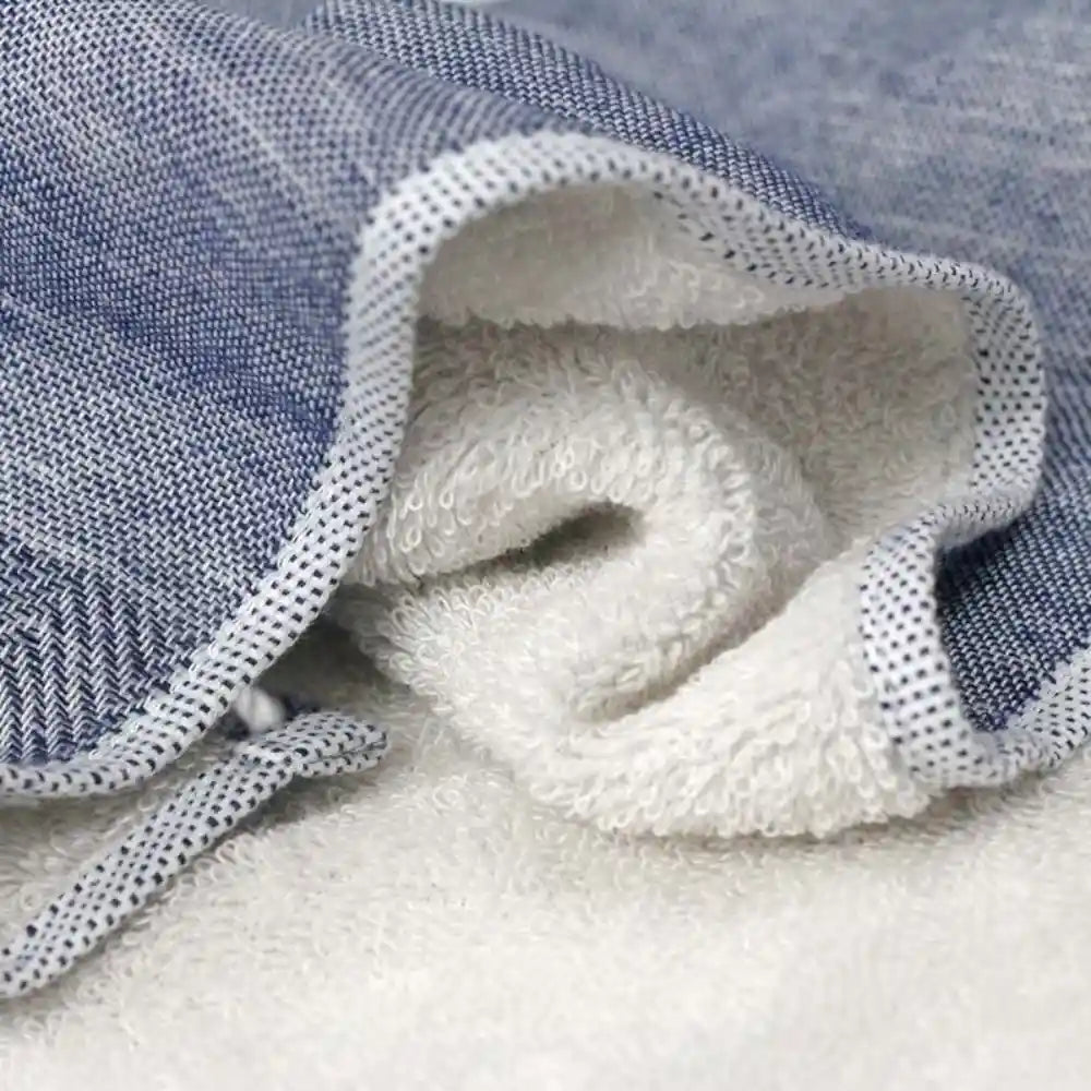 Close-up of a navy Imabari towel with its double-sided design: soft gauze on one side and plush pile on the other.