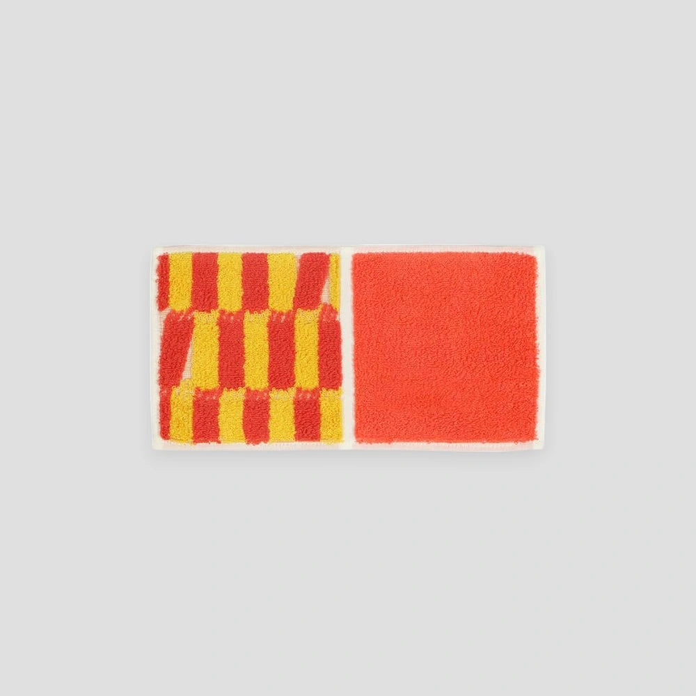 A compact Imabari towel in orange and yellow vibrant patterns, displayed against a white background.