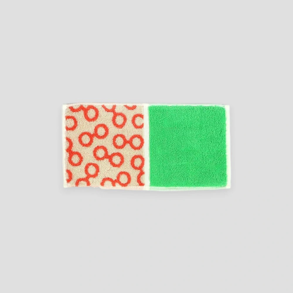 A compact Imabari towel in orange glasses patterns, displayed against a white background.