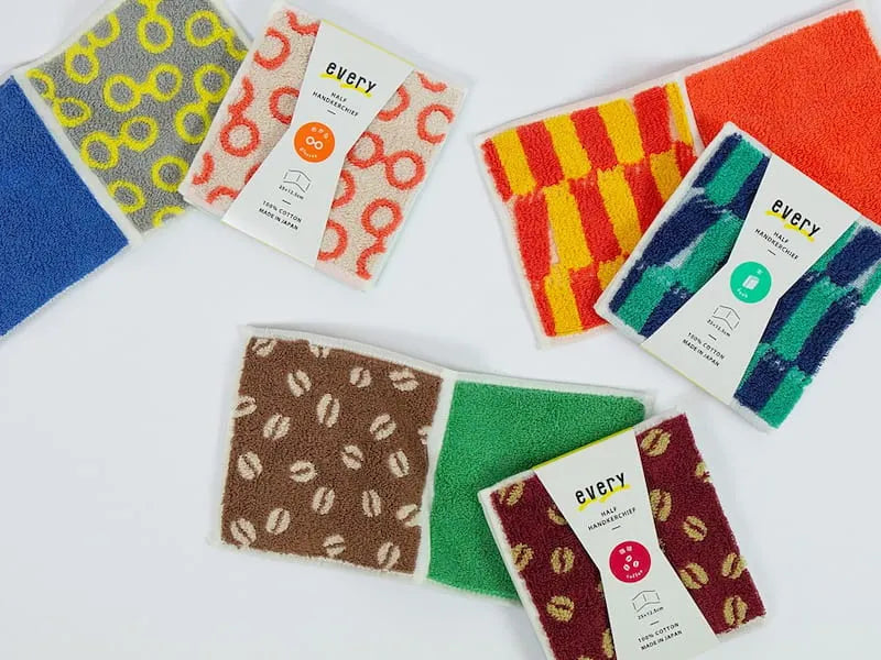 A collection of compact Imabari towel in various vibrant patterns, displayed against a white background.