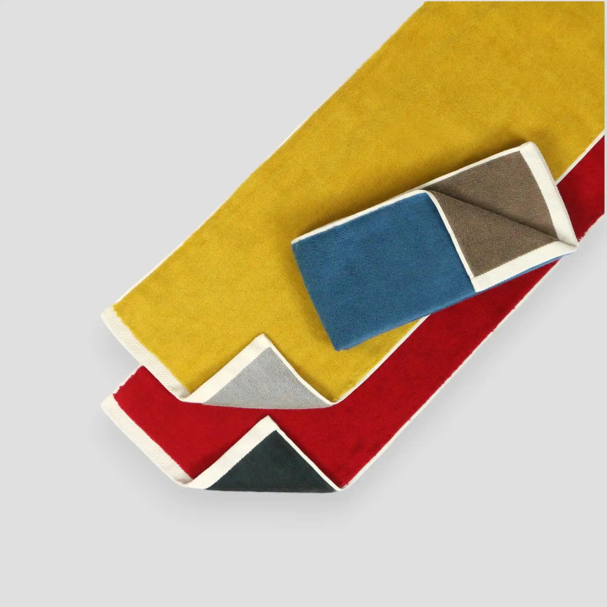A collection of Imabari sports towels in blue, yellow, and red, with a slim profile and reversible design.