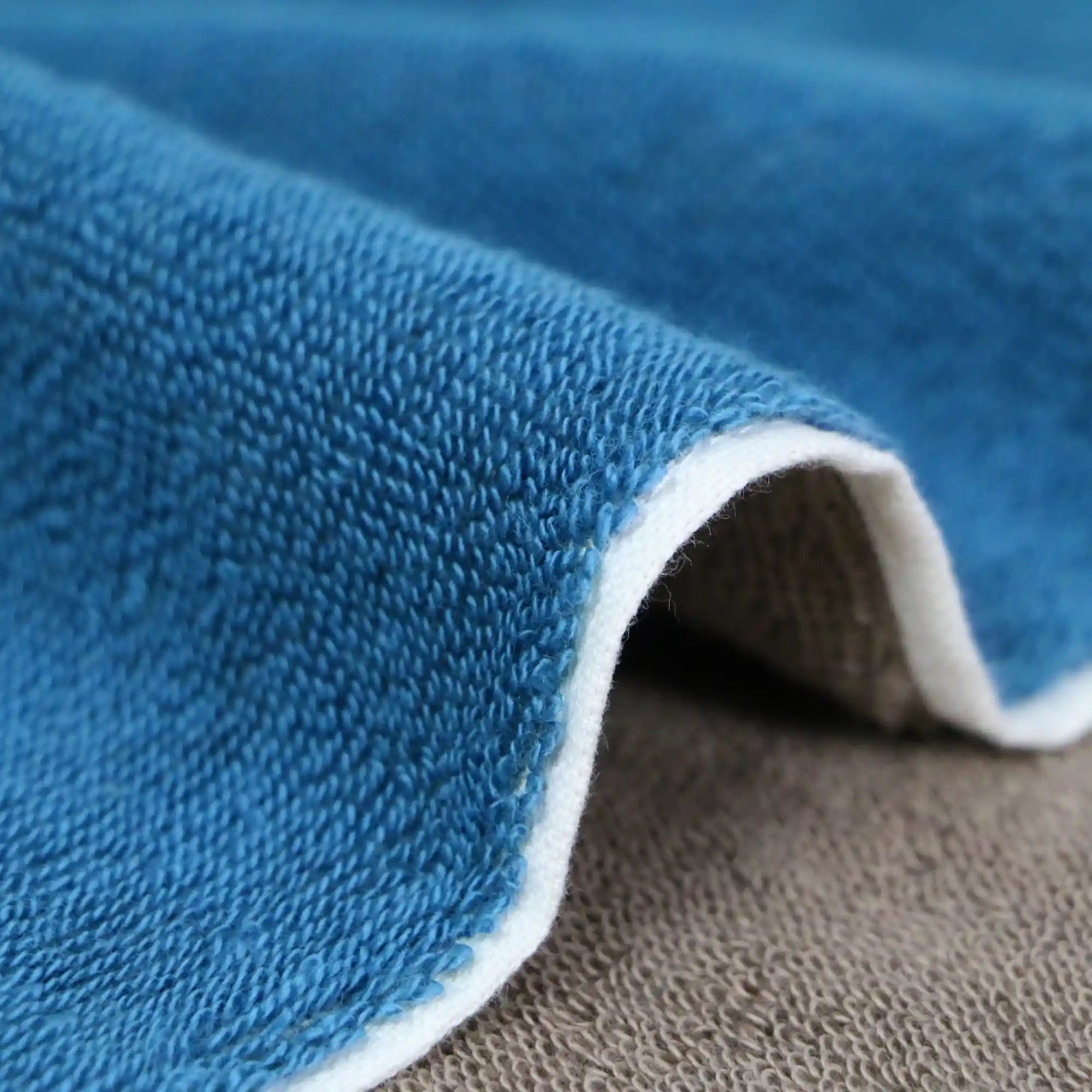 A close-up of the texture and side of a reversible blue and gray Imabari towel