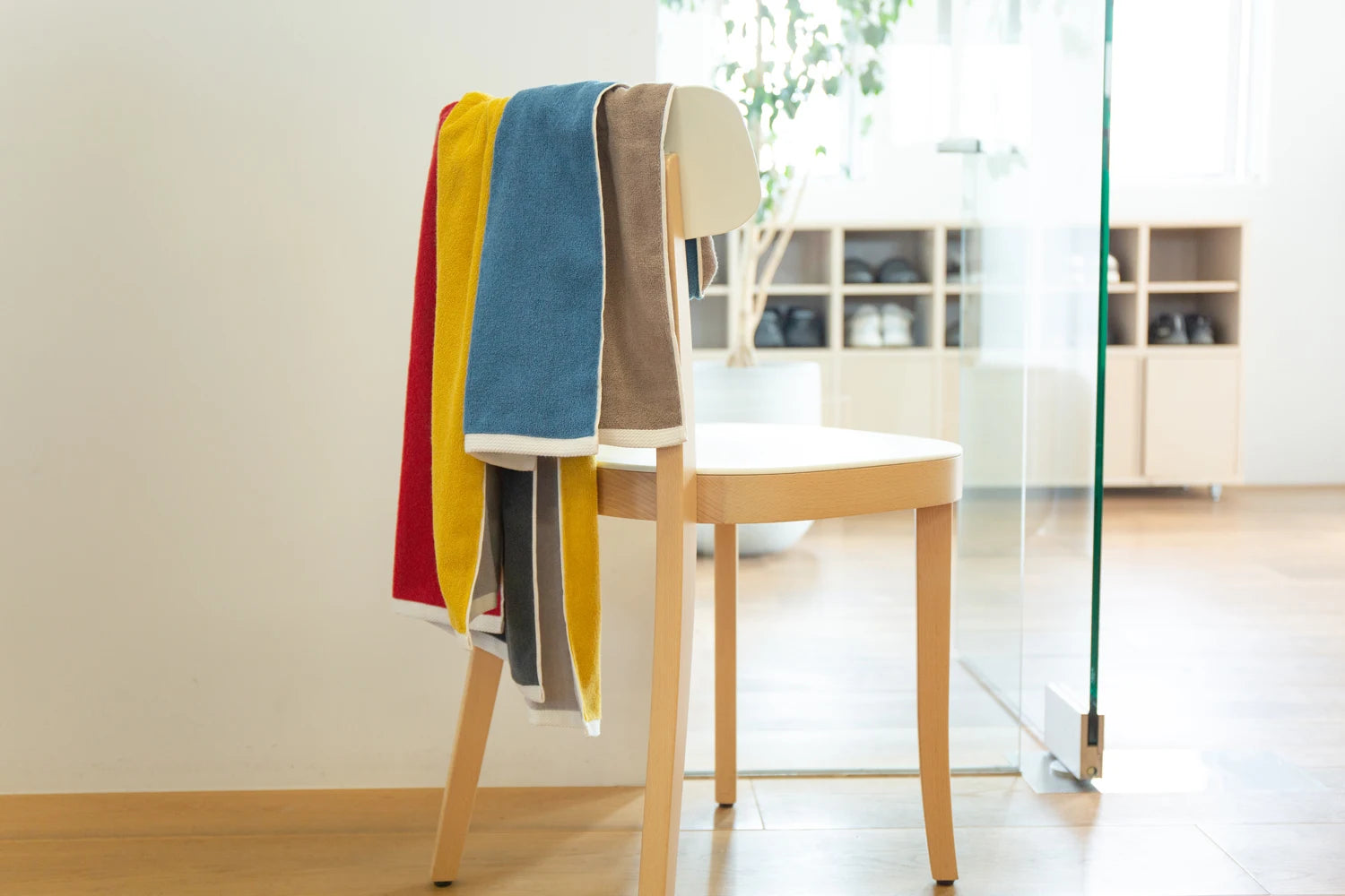 Showing colorful reversible Imabari towels draped over the back of a chair