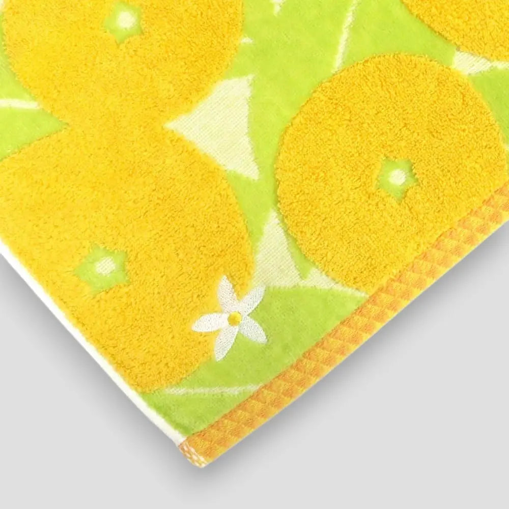 Close-up of a white flower embroidery in the colorful Imabari towel with yellow Iyokan pattern