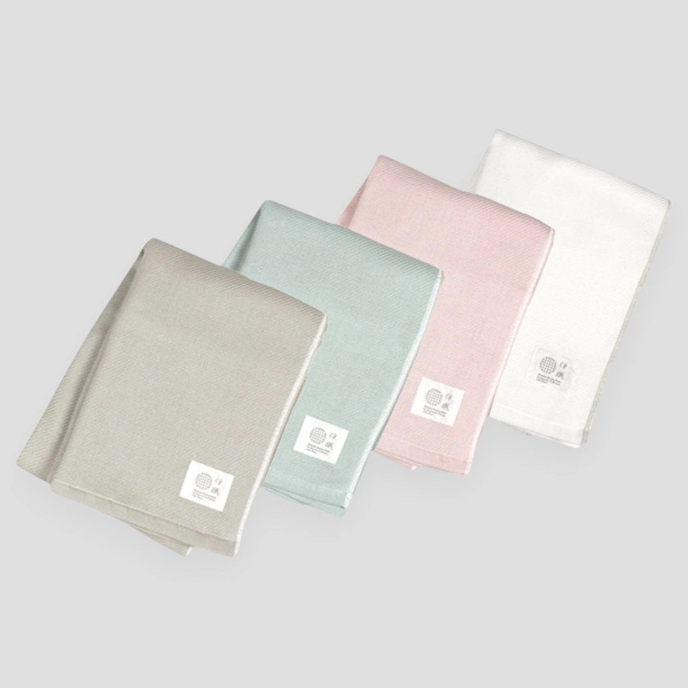 Folded white, pink, blue and gray Imabari towel made from cotton gauze.