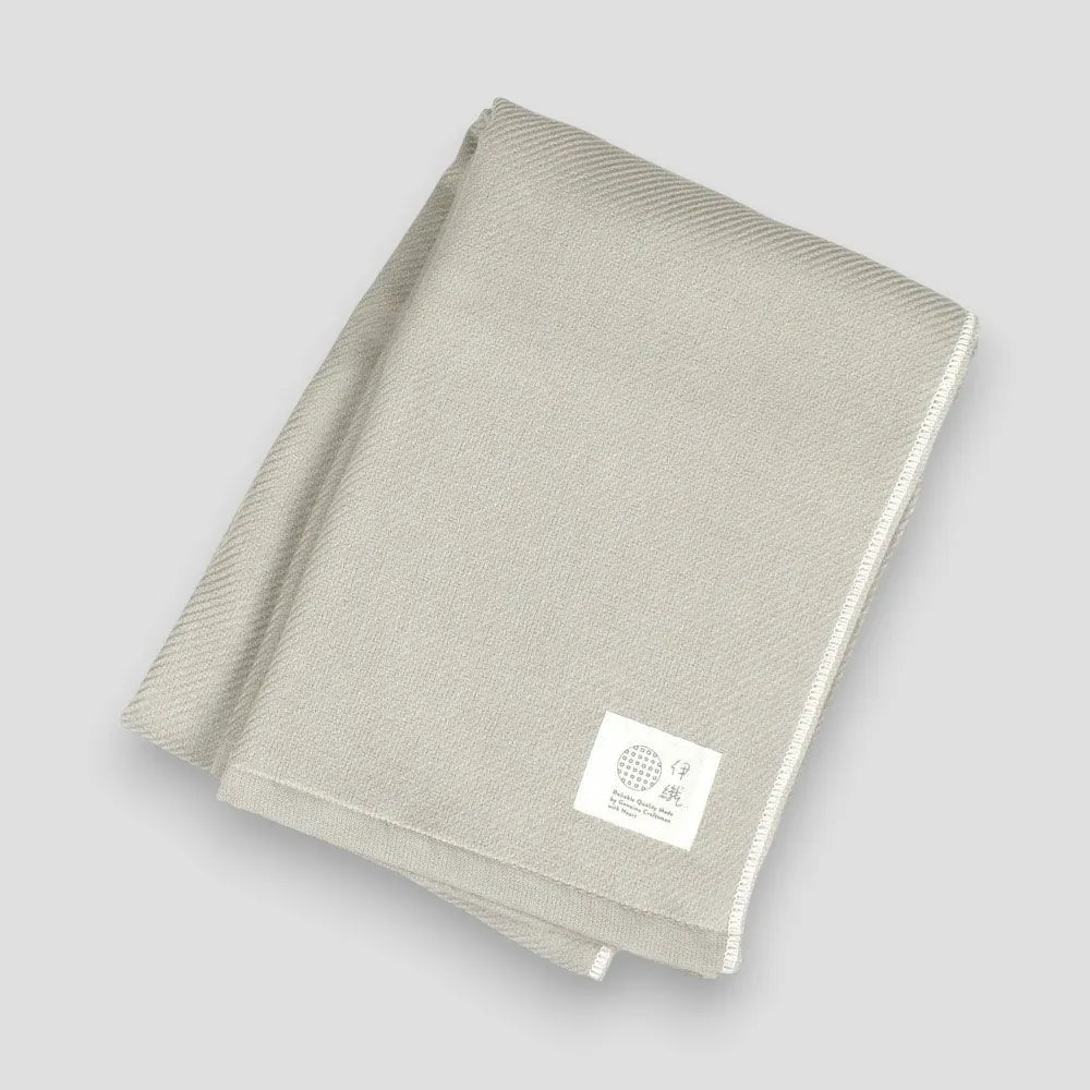 Folded gray Imabari towels made from cotton gauze, branded with a label showing the name &
