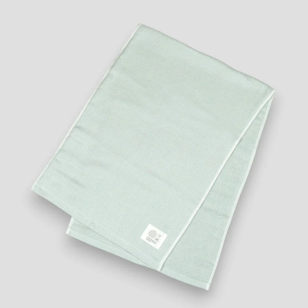 Folded blue Imabari towels made from cotton gauze, branded with a label showing the name &