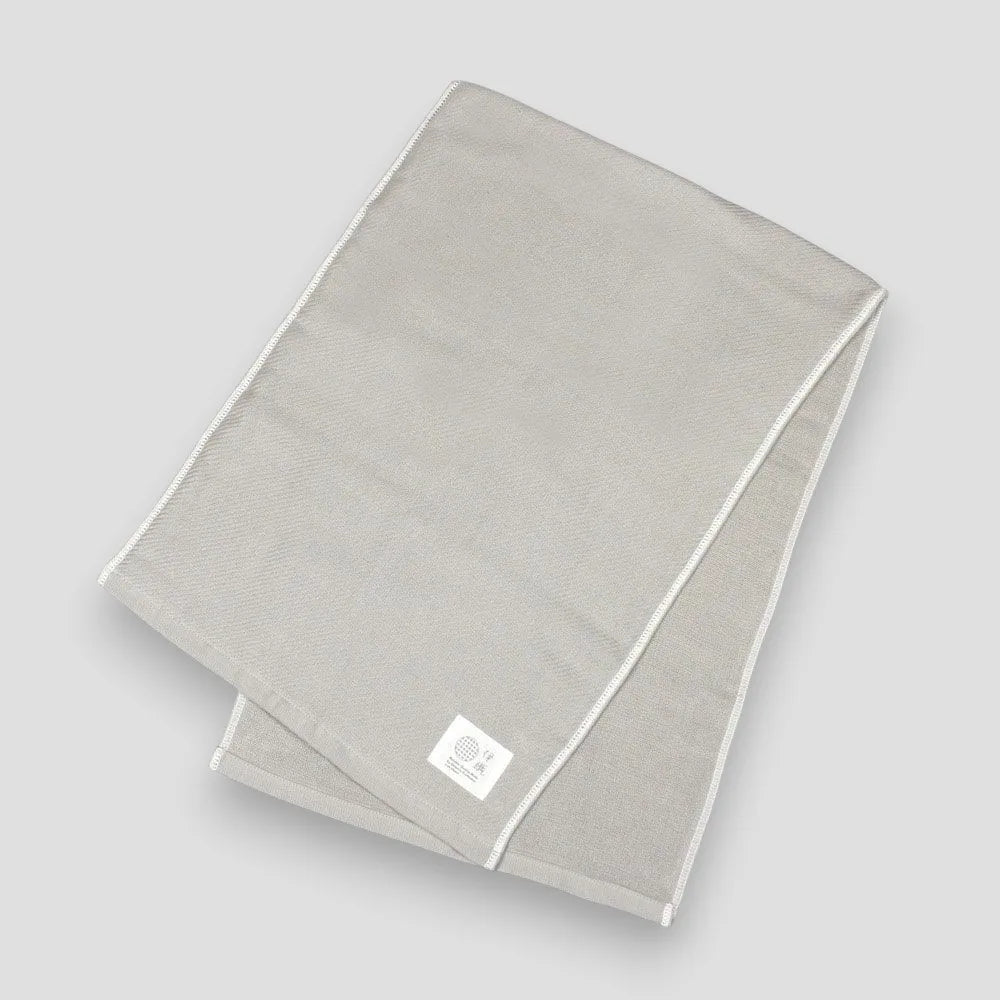 Folded gray Imabari towels made from cotton gauze, branded with a label showing the name &