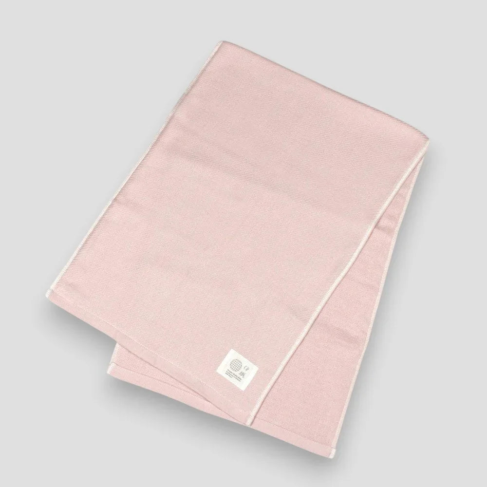Folded pink Imabari towels made from cotton gauze, branded with a label showing the name &