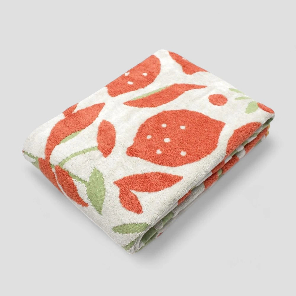 A folded Imabari towel with multicolored patterns, orange tones, made from 100% cotton.