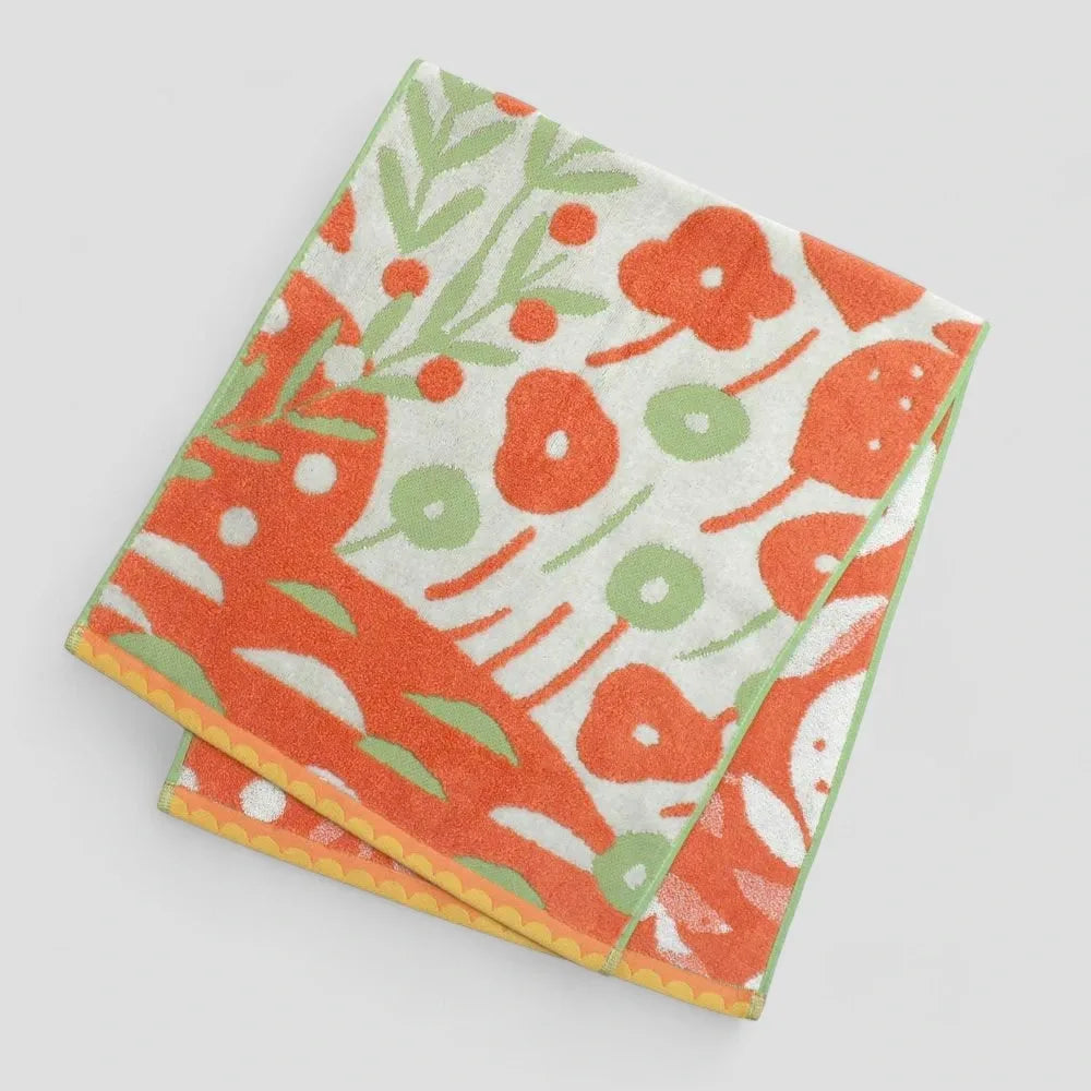 A folded Imabari towel with multicolored patterns, including orange tone made from 100% cotton.
