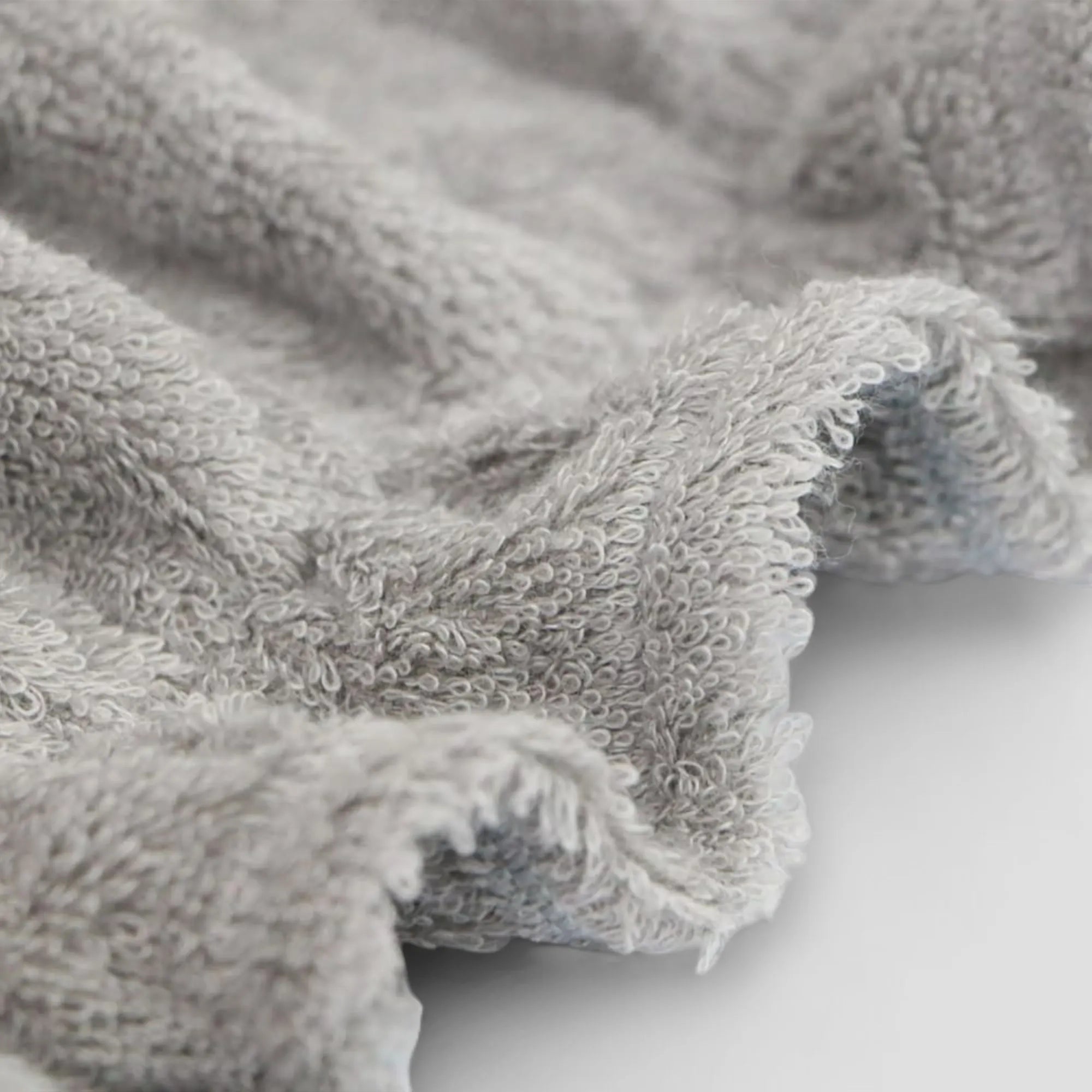 Close-up of a textured gray Imabari towel fabric on a white background