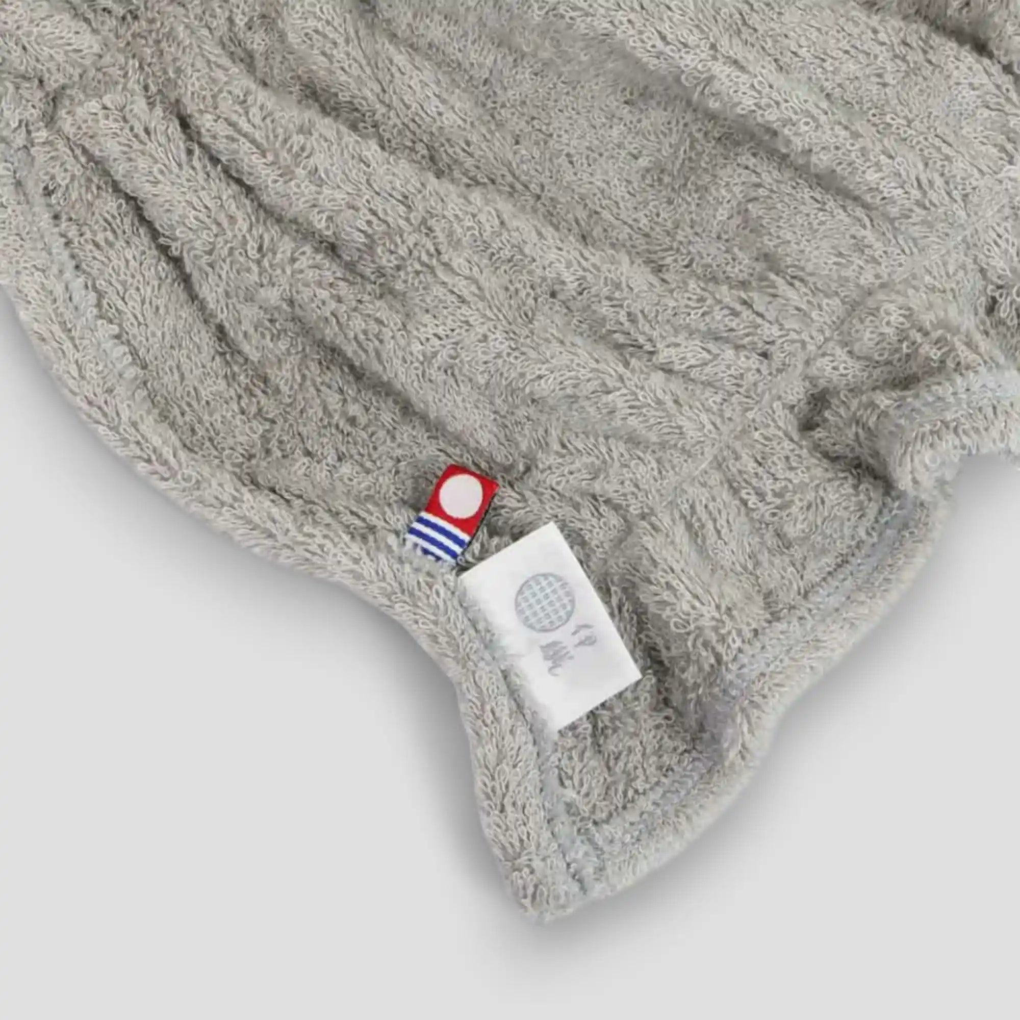 Gray Imabari towel hair-dry-towel with a brand label on a light gray background