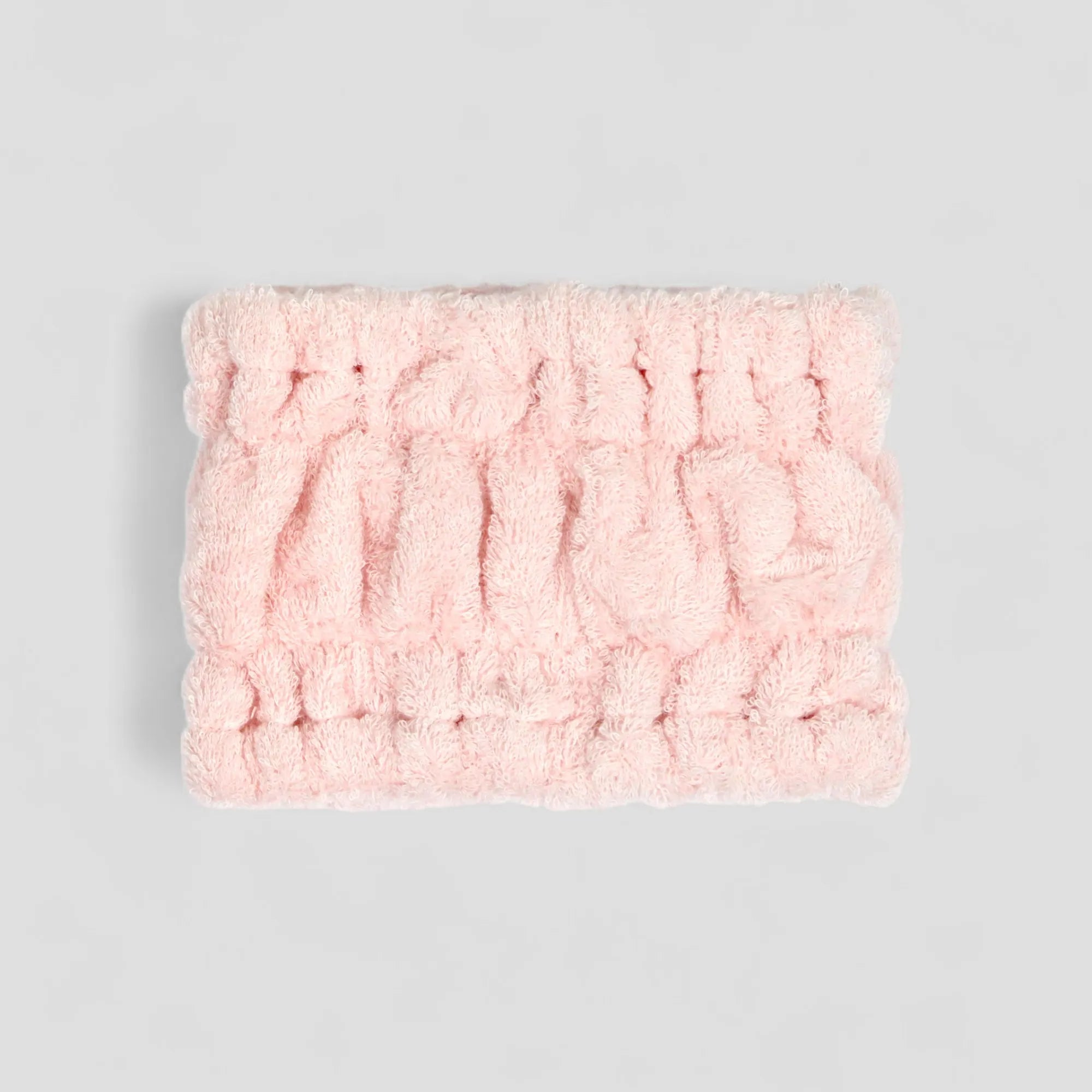 Pink Imabari towel textured head band on a gray background