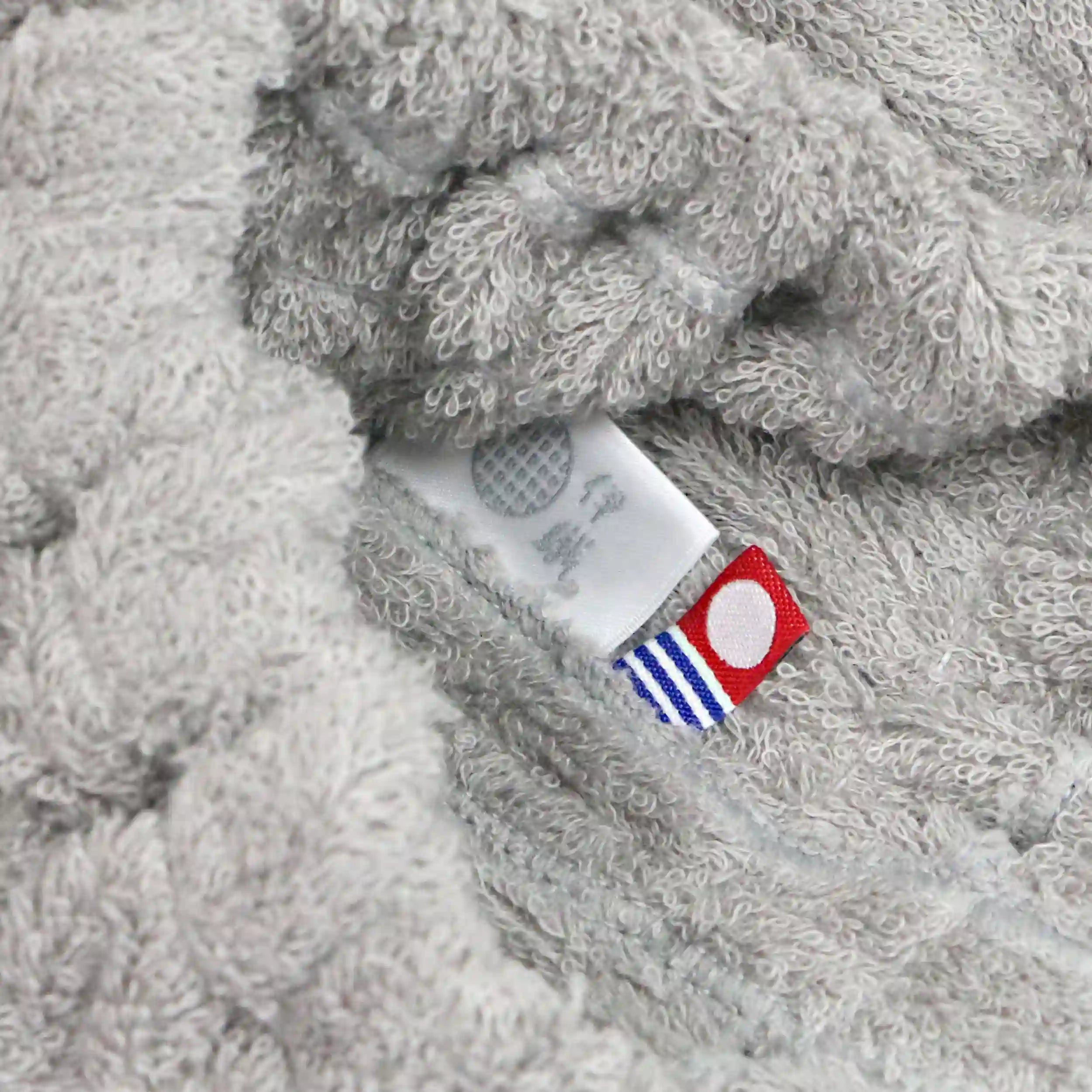 Close-up of gray Imabari towel textured fabric with a brand tag.