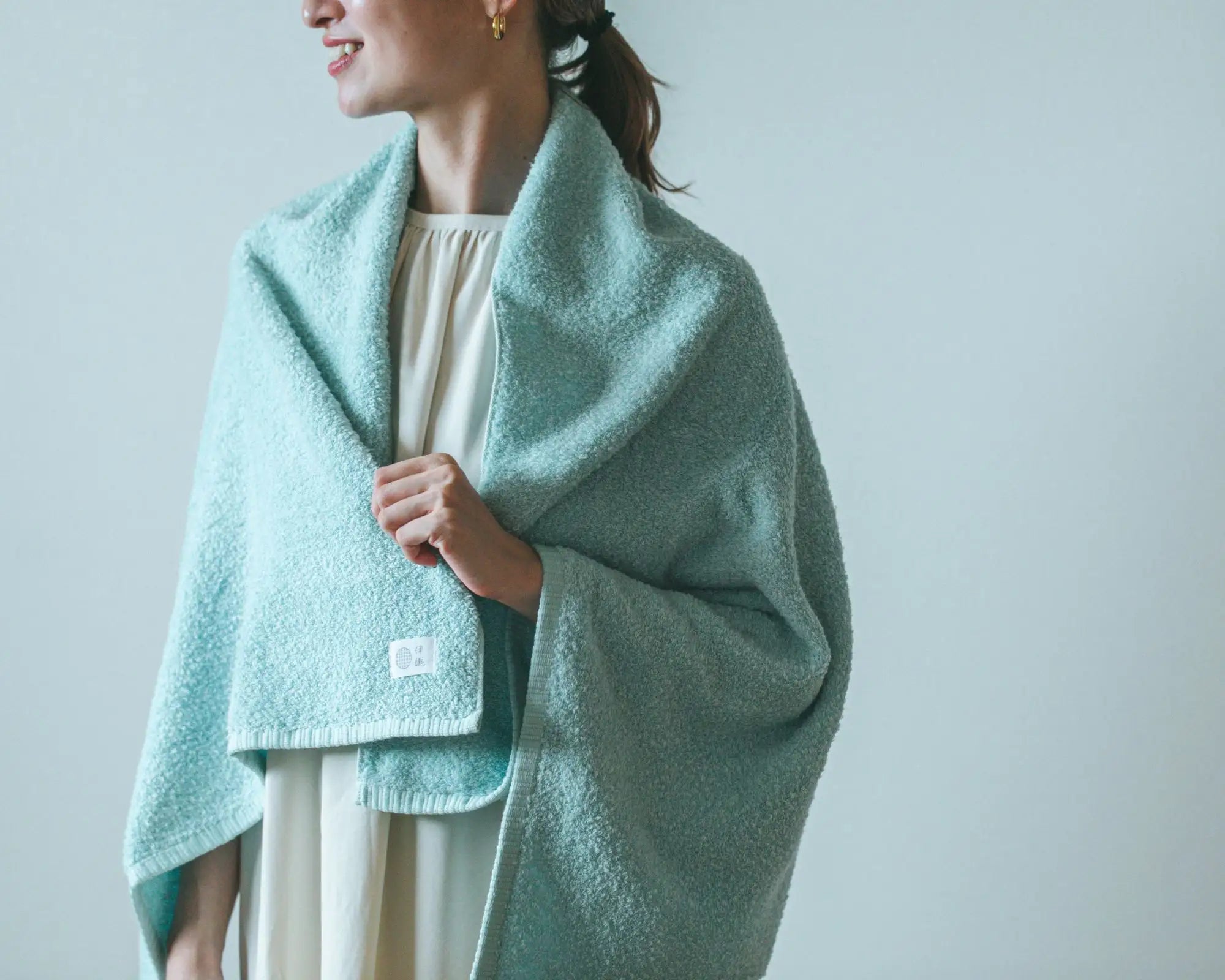 Person wearing a light blue Imabari towel with a plain background