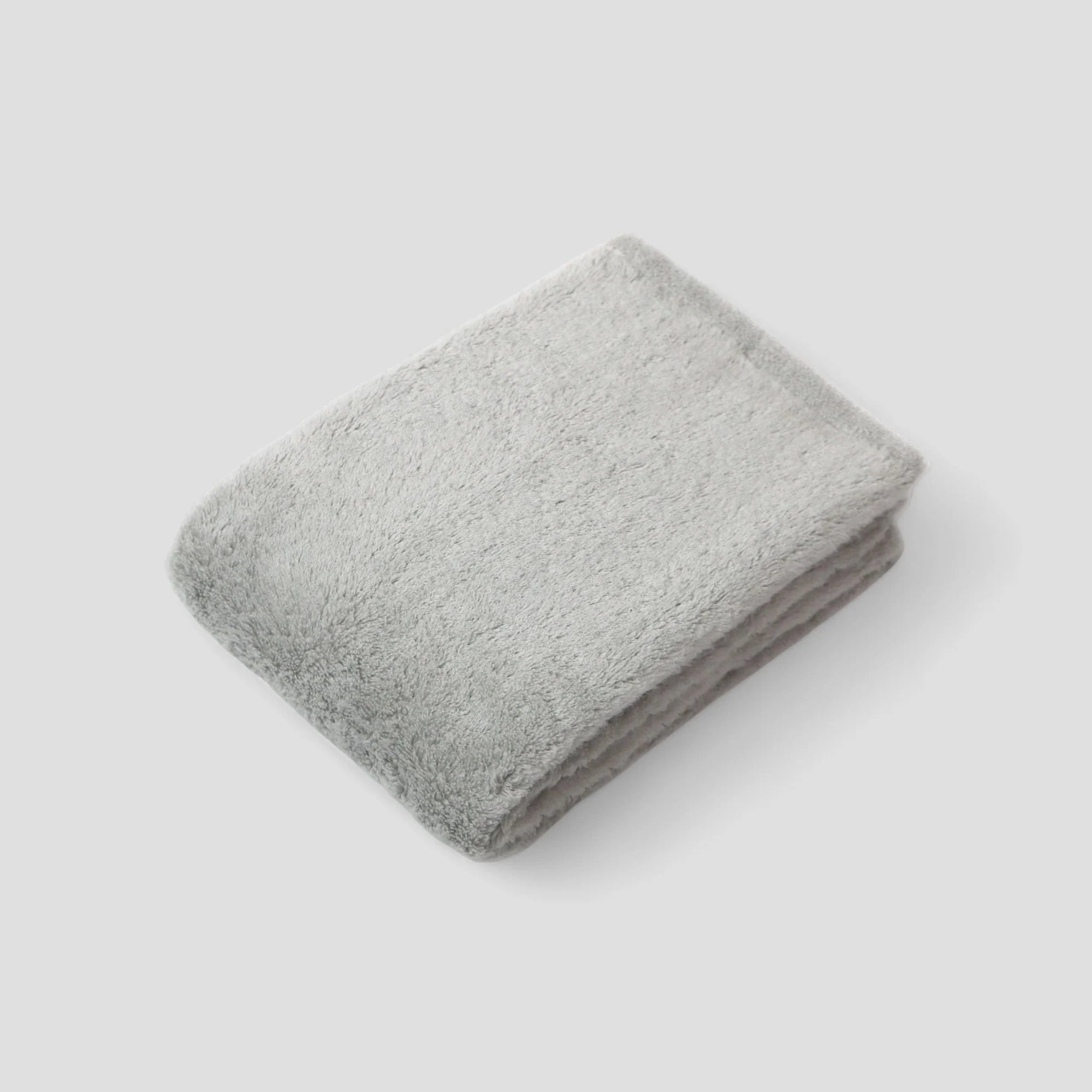 Folded gray Imabari towel on a light gray background